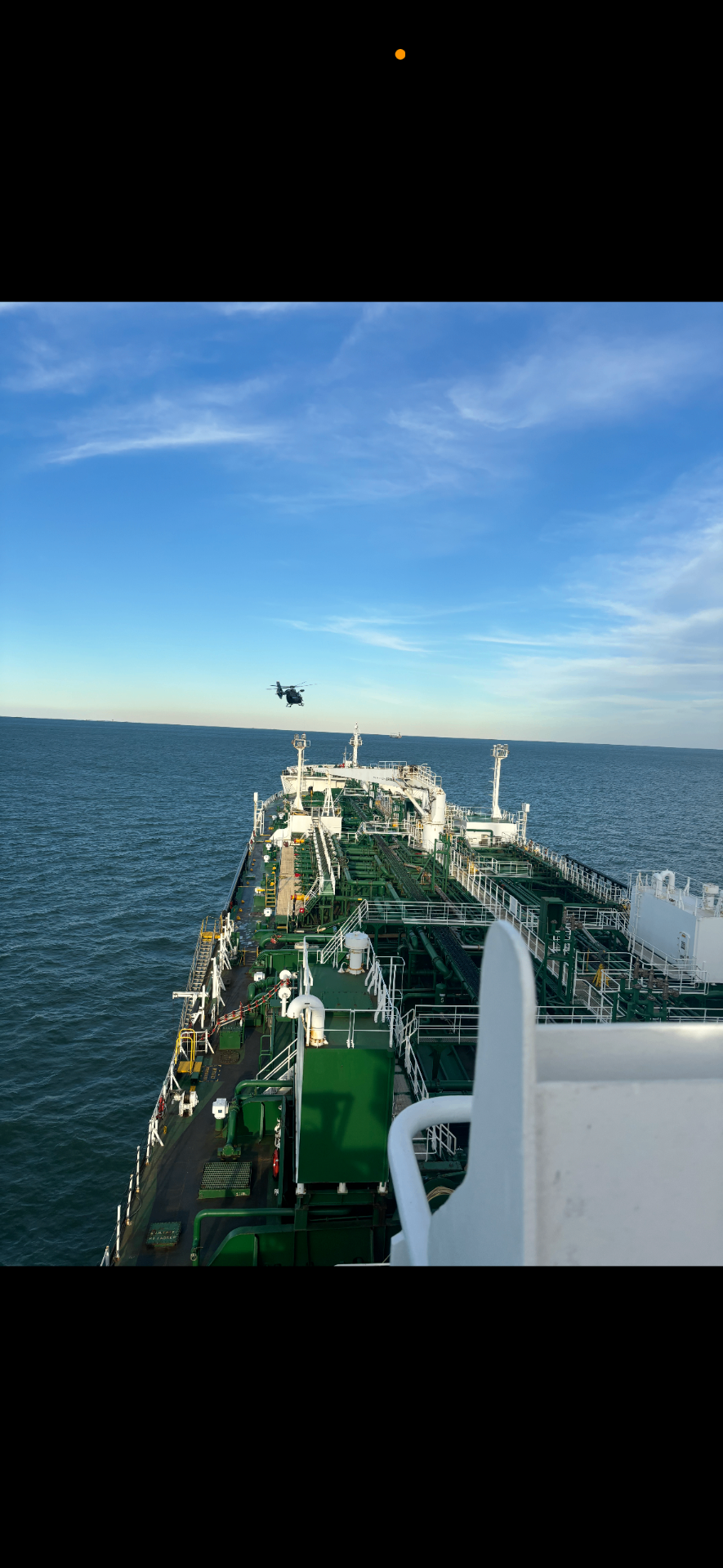Tanker vessel at sea with helicopter approaching