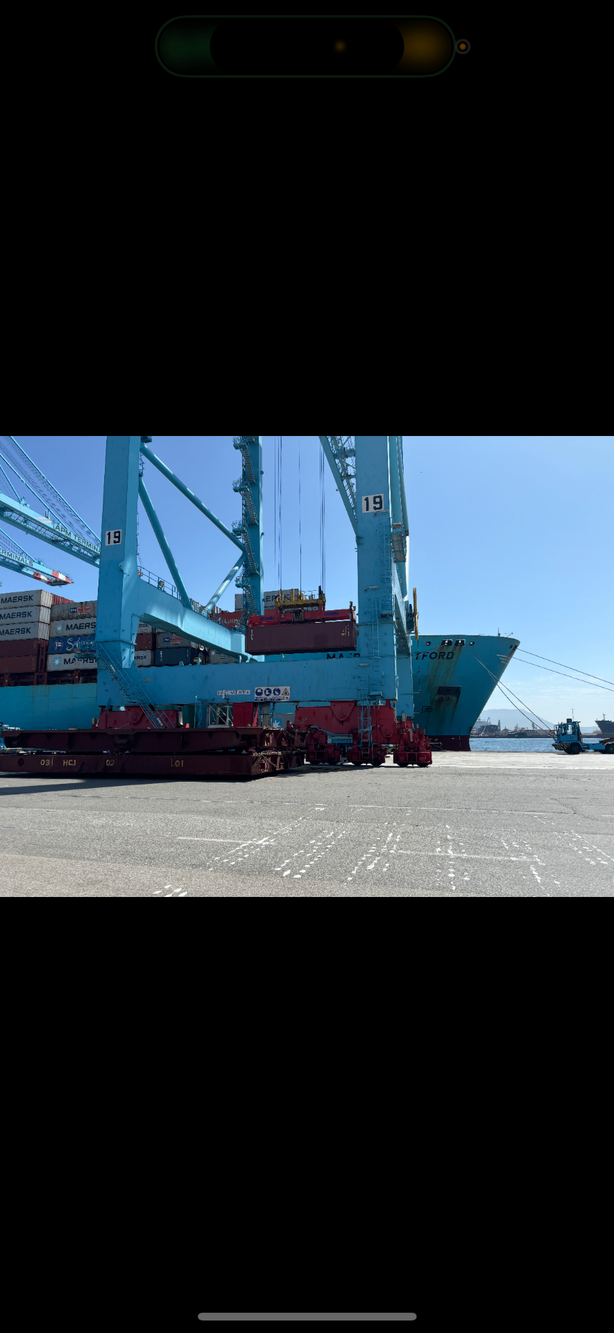 Container port with cranes loading a vessel